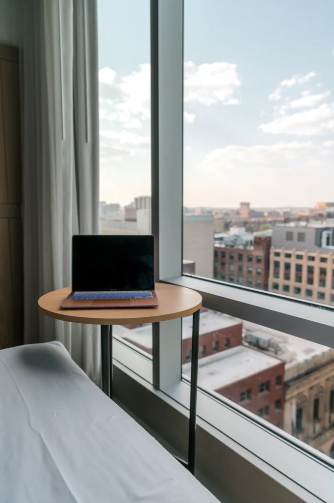 Laptop on a desk beside a large window
